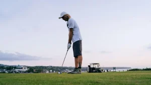 Trust your golf swing: golfer preparing to hit on a scenic course under a clear sky